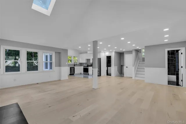 a view of large hall with kitchen and window