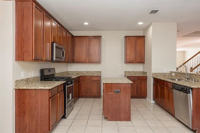 a kitchen with stainless steel appliances granite countertop a stove top oven sink and cabinets