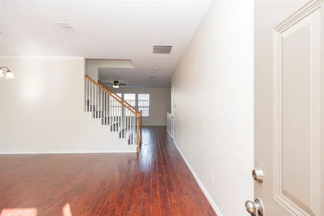 a hallway with wooden floor table and chairs