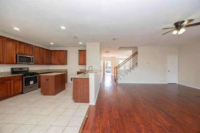 a kitchen with a sink a counter top space stainless steel appliances and cabinets