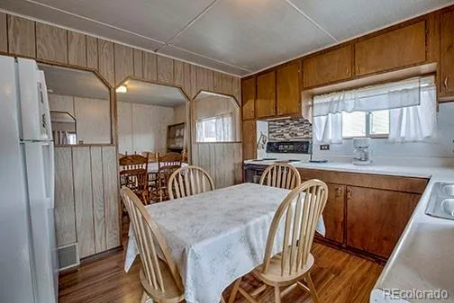 a kitchen with stainless steel appliances granite countertop a sink a microwave refrigerator and chairs