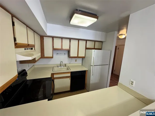 a kitchen with a sink a refrigerator and cabinets