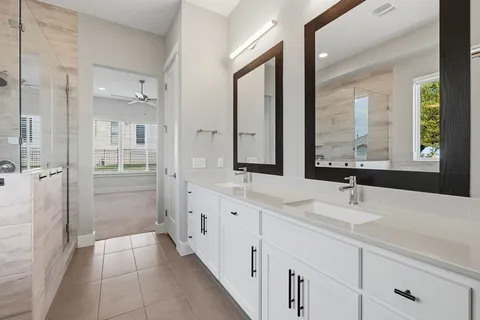 a bathroom with double vanity sinks and a mirror