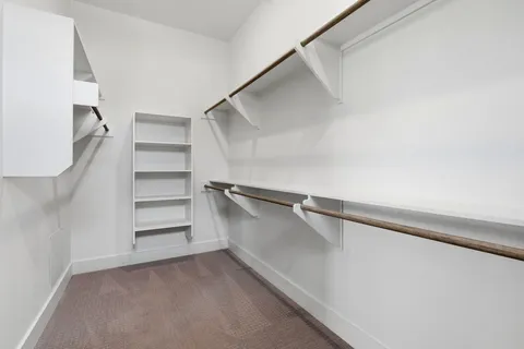 a view of walk in closet with empty racks