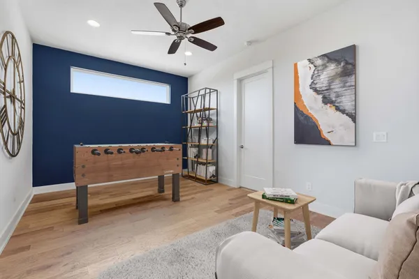 a living room with furniture and a ceiling fan