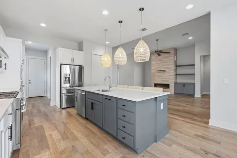 a large kitchen with stainless steel appliances a large counter top and cabinets
