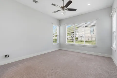 an empty room with a window and a fan