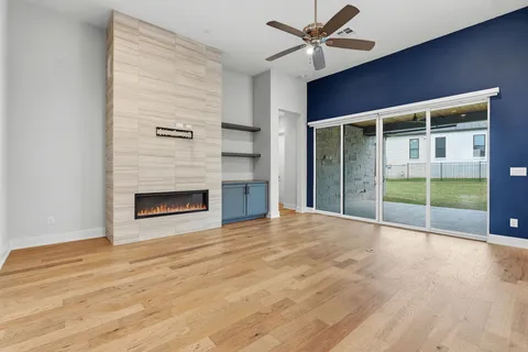 a view of empty room with wooden floor and fireplace