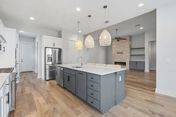 a large kitchen with stainless steel appliances a large counter top and cabinets