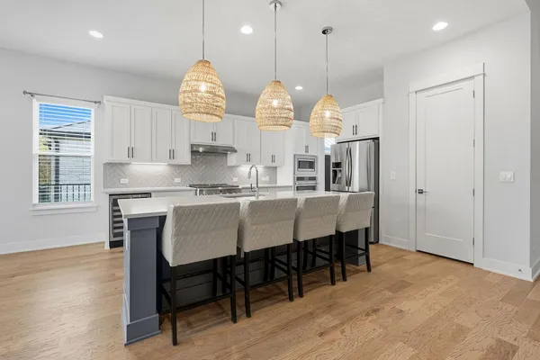 a dining room filled chandelier and wooden floor