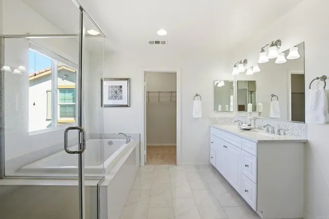 a spacious bathroom with a double vanity sink a mirror and a bathtub