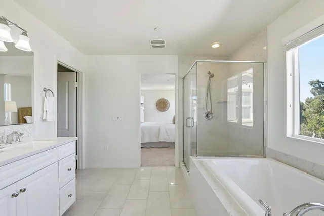 a bathroom with a granite countertop sink a mirror a bathtub and shower