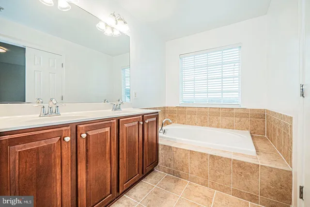 a spacious bathroom with sinks mirror and a bathtub