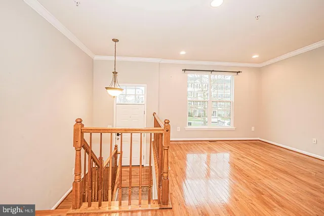 a view of a room with wooden floor fan and windows