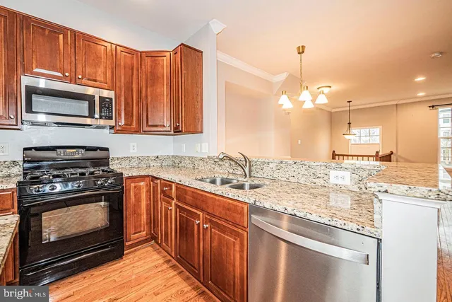 a kitchen with stainless steel appliances granite countertop a stove microwave and sink