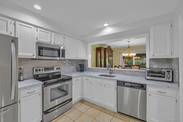 a kitchen with white cabinets appliances and a sink