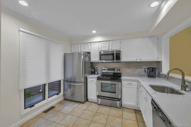 a kitchen with stainless steel appliances granite countertop a refrigerator sink and stove