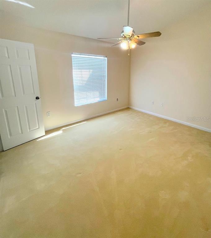2534 Maneshaw Lane Kissimmee, FL 34747 - Photo 27 of 40 en empty room with chandelier fan and windows