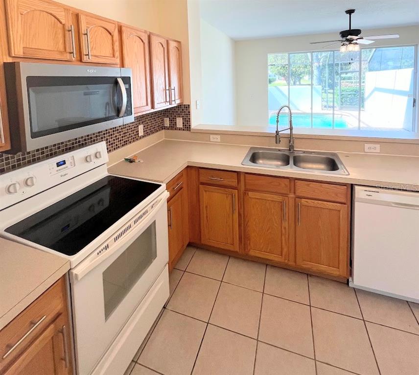 2534 Maneshaw Lane Kissimmee, FL 34747 - Photo 5 of 40 a kitchen with stainless steel appliances a stove microwave and sink