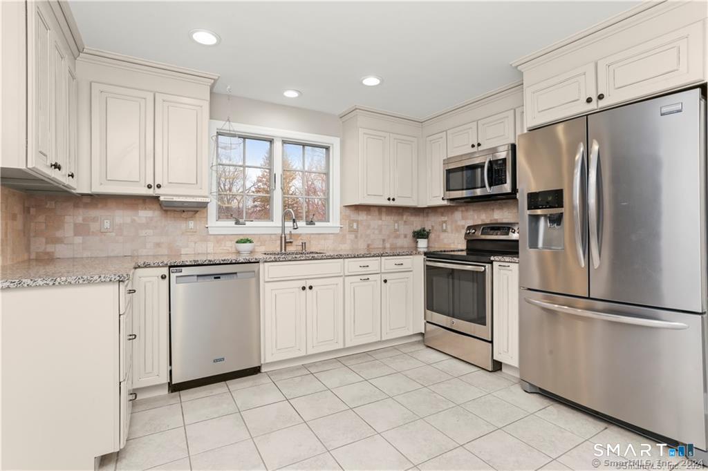 608 Stillson Road Fairfield, CT 06824 - Photo 4 of 16 a kitchen with white cabinets stainless steel appliances and a window