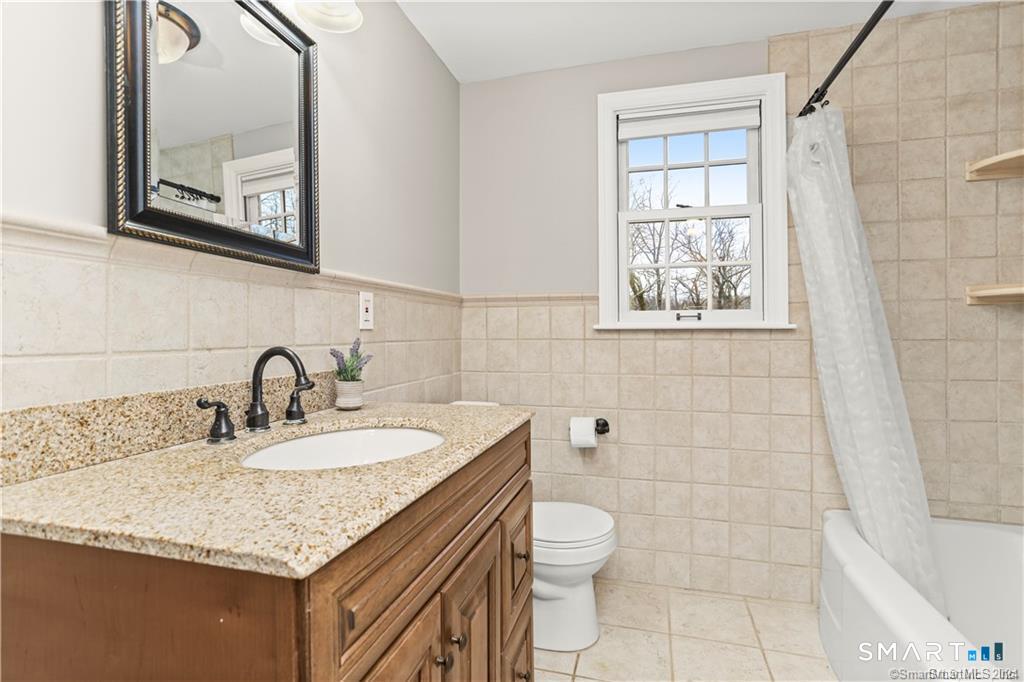608 Stillson Road Fairfield, CT 06824 - Photo 5 of 16 a bathroom with a granite countertop sink a toilet and a mirror