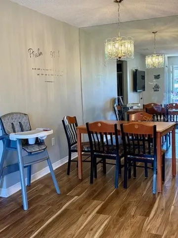 a view of a dining room with furniture wooden floor and chandelier