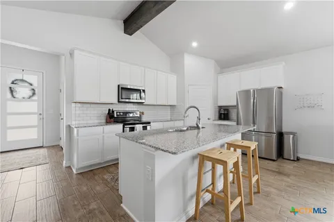a kitchen with stainless steel appliances granite countertop a refrigerator stove a sink and a microwave