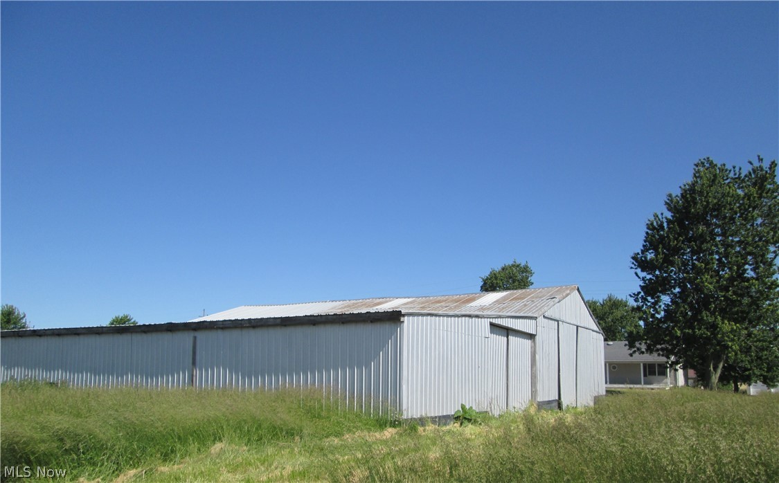 13096 Smith Road Wellington, OH 44090 - Photo 7 of 24 Metal-sided outbuilding featuring a gable roof and corrugated metal siding=other side of barn