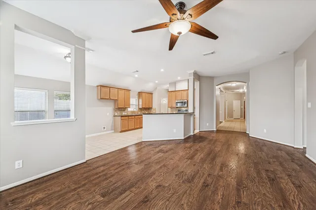 a view of a kitchen with wooden floor and a kitchen space with a sink