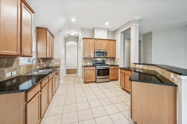 a kitchen with stainless steel appliances granite countertop a sink stove and refrigerator