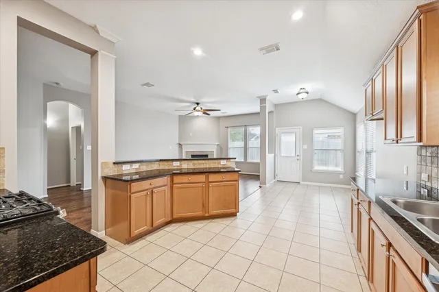 a large kitchen with granite countertop a stove a sink dishwasher and a refrigerator