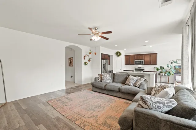 a living room with furniture kitchen view and a chandelier