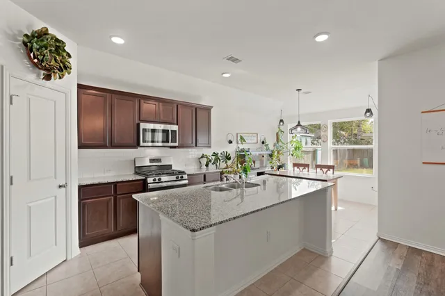 a kitchen with stainless steel appliances granite countertop a sink stove and refrigerator