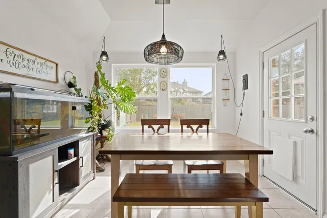 a dining room with table chairs and kitchen view