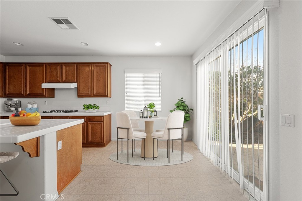 44855 Rutherford Street Temecula, CA 92592 - Photo 8 of 31 a kitchen with stainless steel appliances granite countertop a refrigerator a sink dishwasher and white cabinets with wooden floor