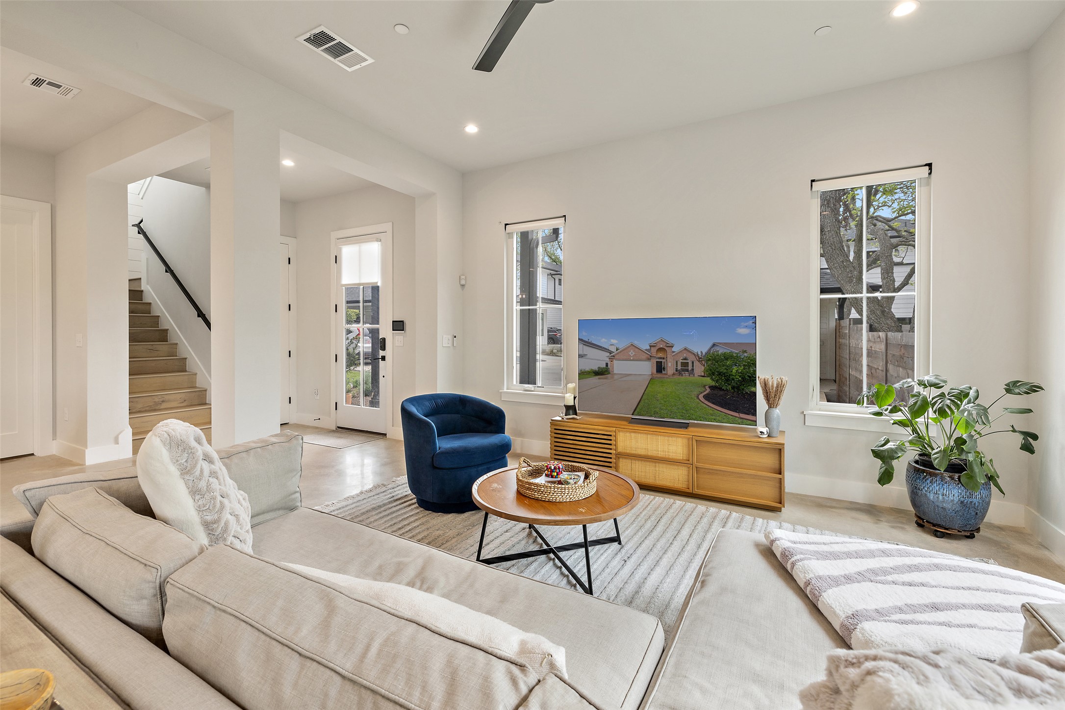 1504 Ruth Avenue, Unit 3 Austin, TX 78757 - Photo 5 of 39 Step inside this well-lit living room, featuring a welcoming entry, high ceilings, and resilient concrete flooring.