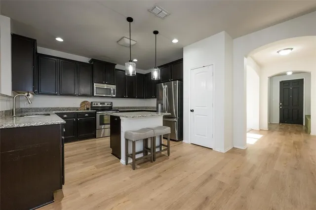 a kitchen with a stove a refrigerator and a microwave