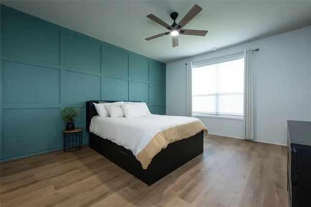 a bedroom with a bed and a ceiling fan