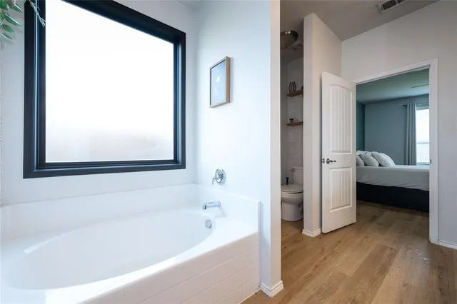 a bathroom with a bathtub and a view of bathroom