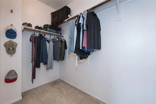 a view of walk in closet with clothes and shoes