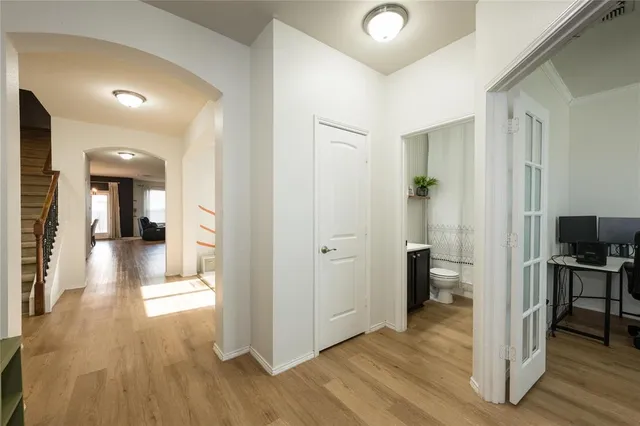 a view of a hallway with wooden floor windows and a livingroom