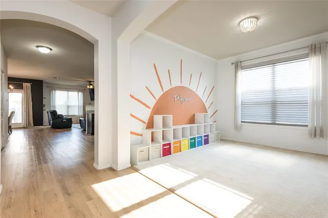 a view of an empty room with window and wooden floor