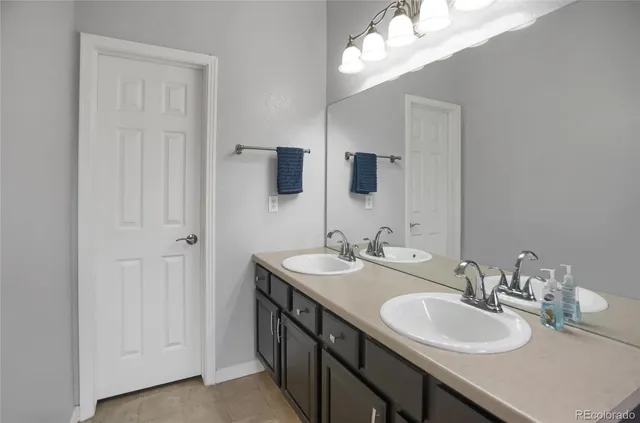 a bathroom with double sink and a mirror