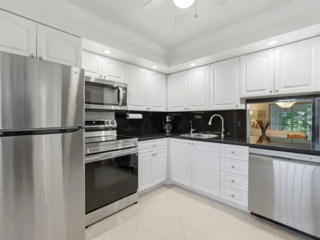 a kitchen with stainless steel appliances granite countertop a refrigerator sink and stove