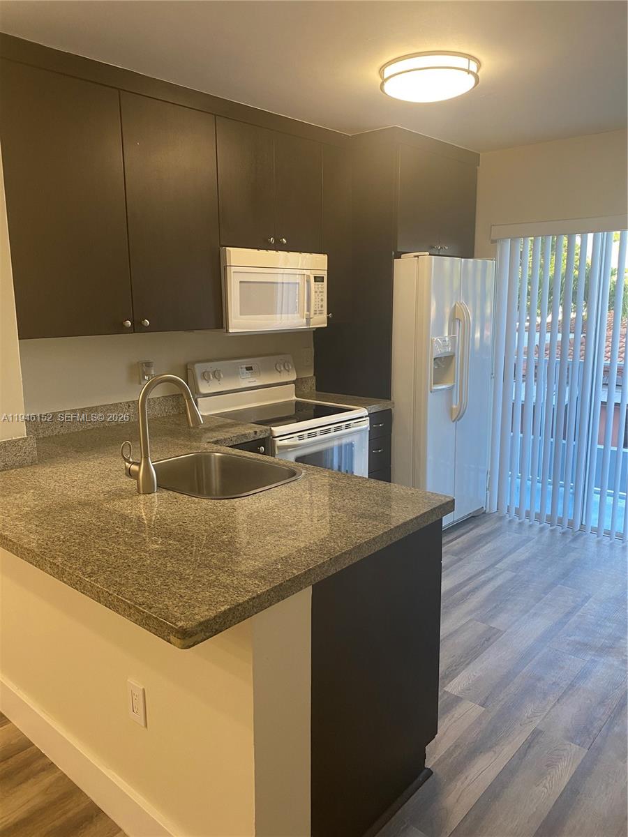 2575 Southwest 27th Avenue, Unit 212 Coconut Grove, FL 33133 - Photo 3 of 12 a kitchen with sink cabinets and wooden floor