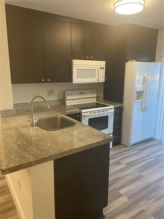 a kitchen with a sink a stove and a refrigerator