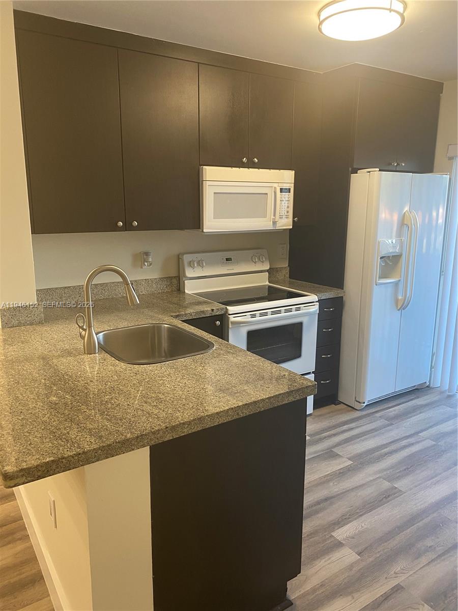 2575 Southwest 27th Avenue, Unit 212 Coconut Grove, FL 33133 - Photo 4 of 12 a kitchen with a sink a stove and a refrigerator