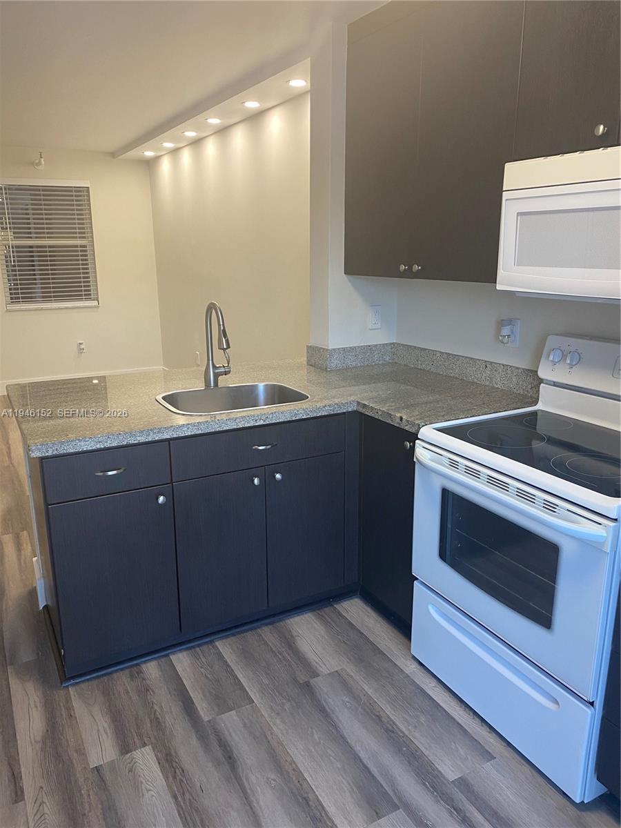 2575 Southwest 27th Avenue, Unit 212 Coconut Grove, FL 33133 - Photo 5 of 12 a kitchen with a sink and a stove