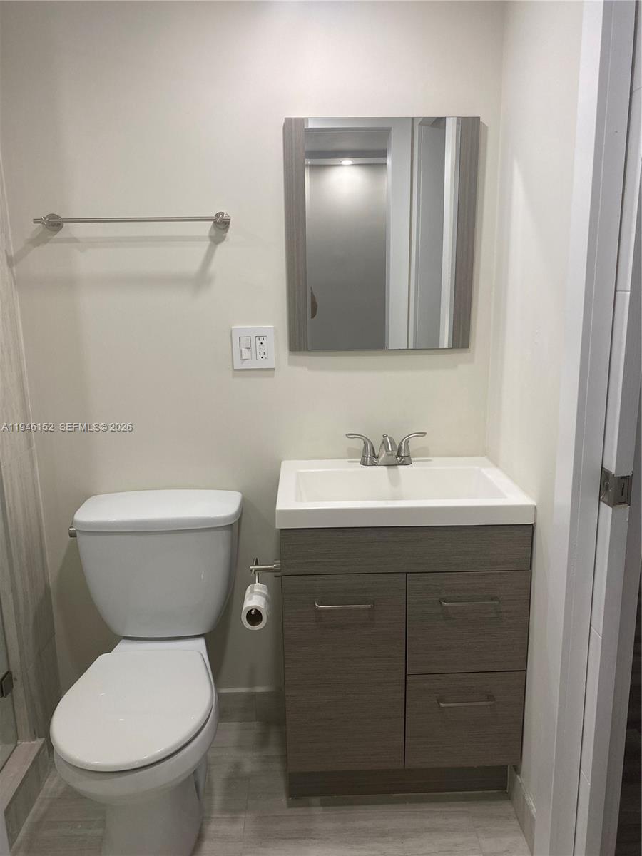 2575 Southwest 27th Avenue, Unit 212 Coconut Grove, FL 33133 - Photo 8 of 12 a bathroom with a toilet sink vanity and mirror