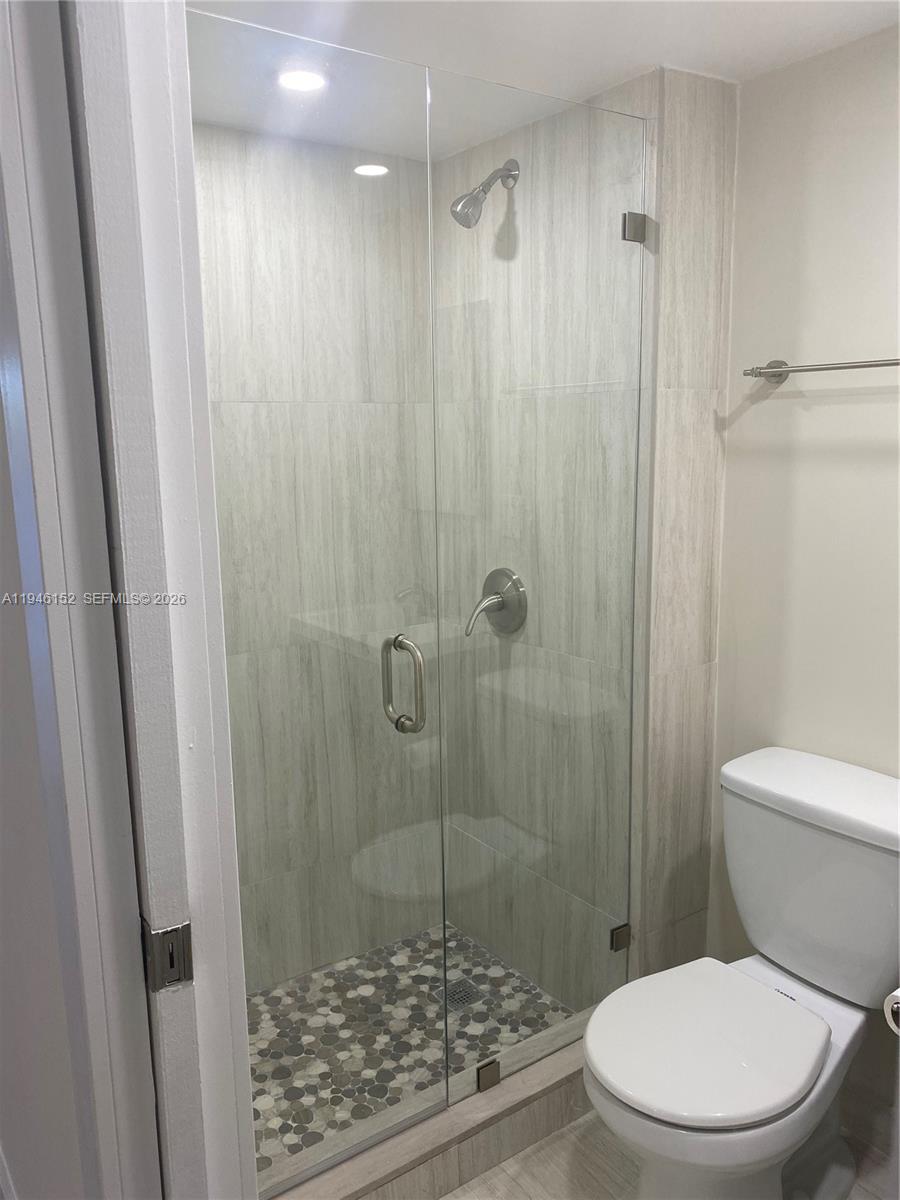 2575 Southwest 27th Avenue, Unit 212 Coconut Grove, FL 33133 - Photo 9 of 12 a white toilet sitting next to a shower